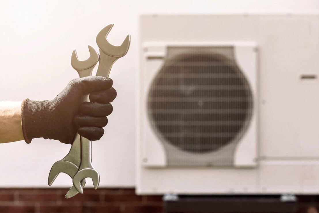 Holding spanners next to an air source heat pump