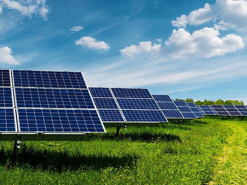 Solar panels a grassy field with a blue sky